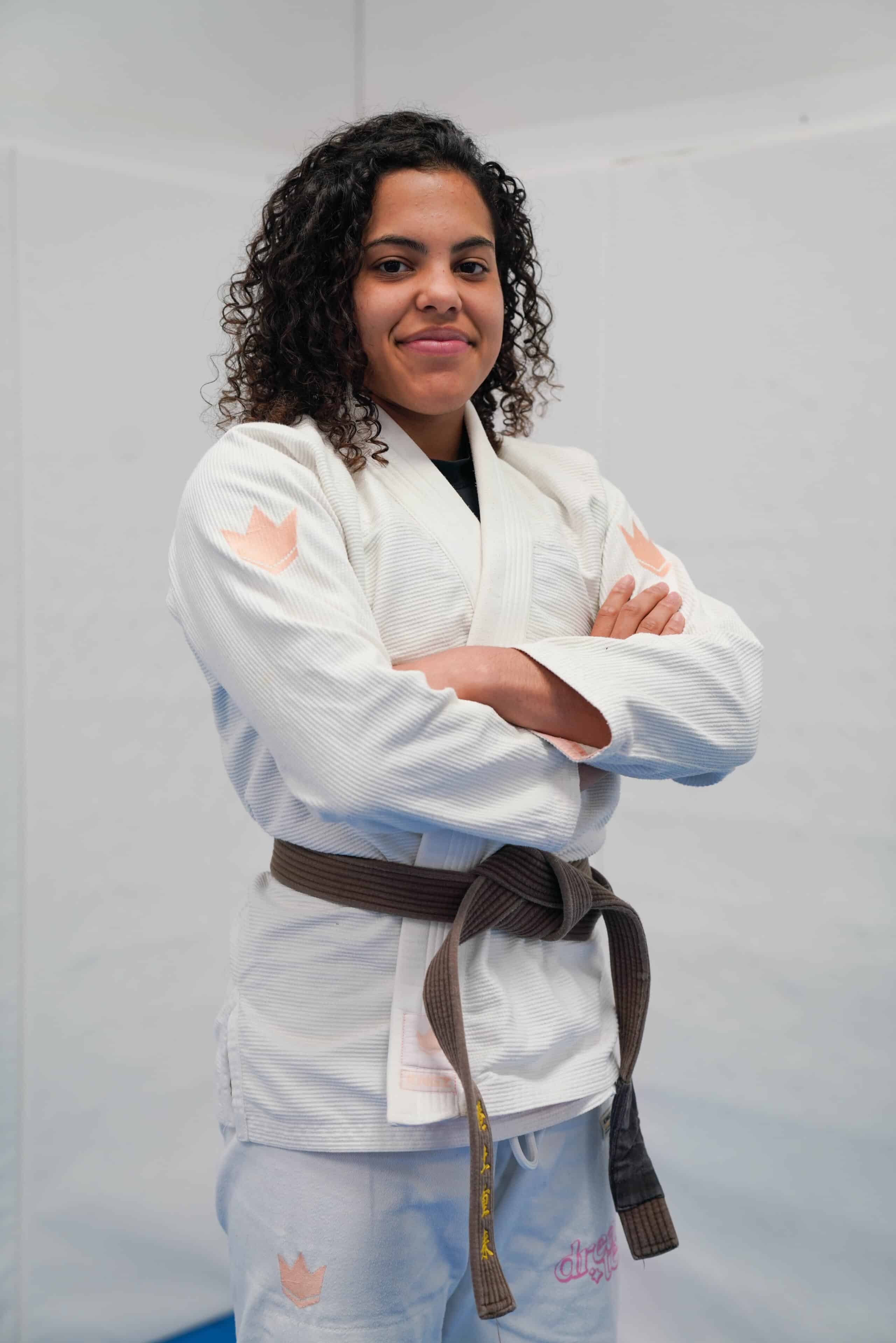 Sarah Galvao, Atos brown belt lightweight champion, smiling in competition gi